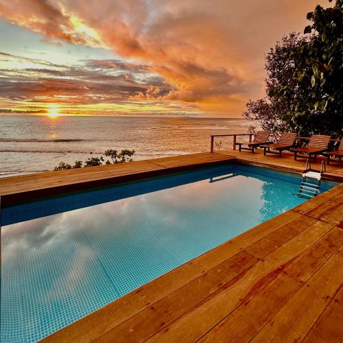 a swimming pool with a view of the ocean at BatuRundung Surf Resort in Naibos