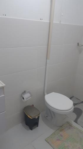 een witte badkamer met een toilet en een plattegrond op de vloer bij Kitinete perto da Praia in Vila Velha