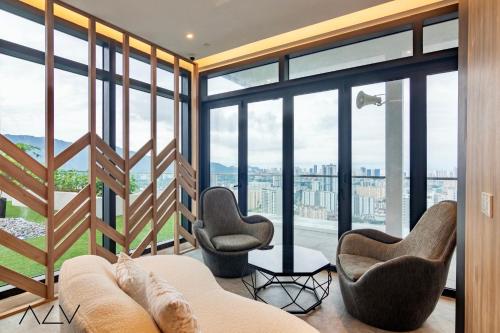 a living room with a couch and chairs and windows at Urban Suites, Signature Collection by Stellar ALV in Jelutong