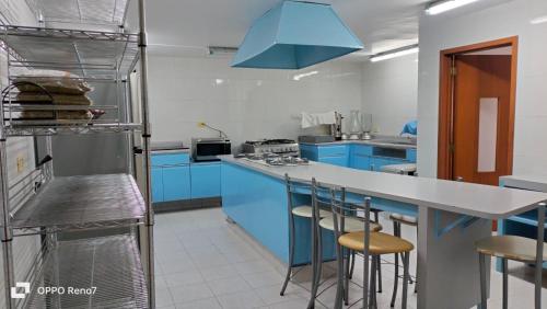 a kitchen with blue cabinets and a counter with stools at Habitaciones remodeladas con areas comunes in Momoxpan