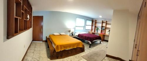 a bedroom with a bed with a yellow blanket on it at Habitaciones remodeladas con areas comunes in Momoxpan