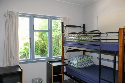 a room with bunk beds and a window at Hippo Lodge Backpackers in Queenstown