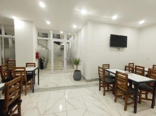 une salle à manger avec des tables et des chaises et une télévision à écran plat dans l'établissement Catalina Hotel, à Colón