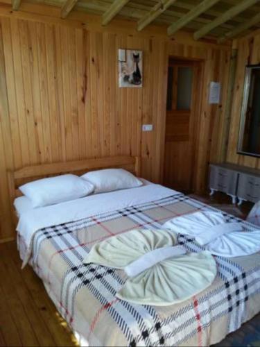 ein großes Bett in einem Zimmer mit Holzwänden in der Unterkunft Casa la montañita in Quito