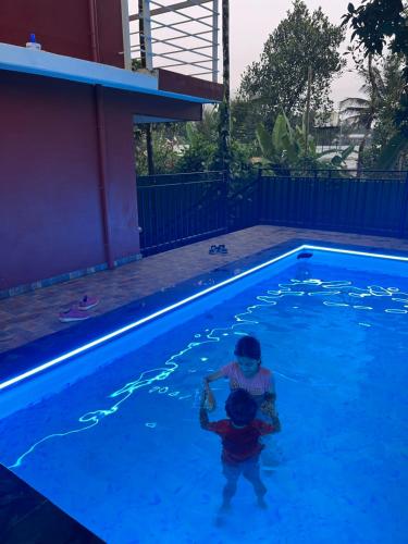 a young child playing in a swimming pool at Easy Inn Wayanad in Kaniyāmbetta