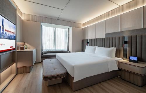 Intercity Shenzhen Futian Huanggang في شنجن: غرفه فندقيه سرير كبير وتلفزيون