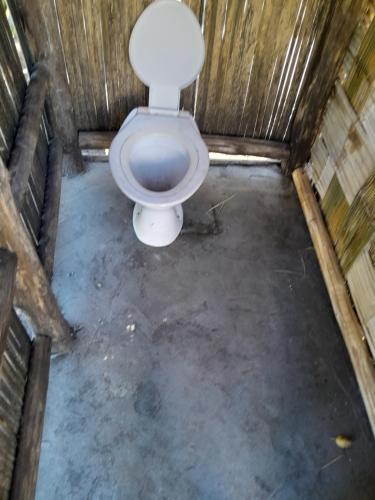 a bathroom with a toilet in a wooden stall at Glowing Mountain view tree house in Loanengo