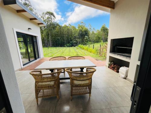 a patio with a table and chairs and a fireplace at 21 Heather Road in George