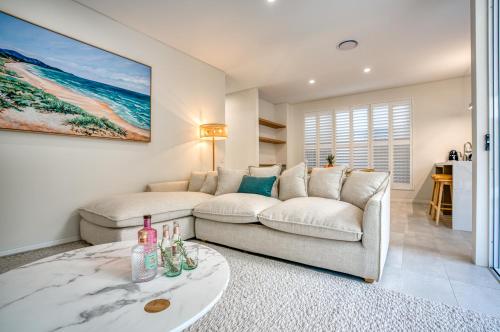 a living room with a couch and a table at Essence Peregian Beach in Peregian Beach