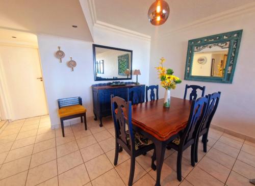 a dining room with a table and chairs and a mirror at Ripple In Time -BBQ - Aircons- 4 Adults 2 kids in Umdloti
