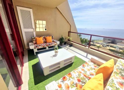 a balcony with a couch and a coffee table at Ripple In Time -BBQ - Aircons- 4 Adults 2 kids in Umdloti