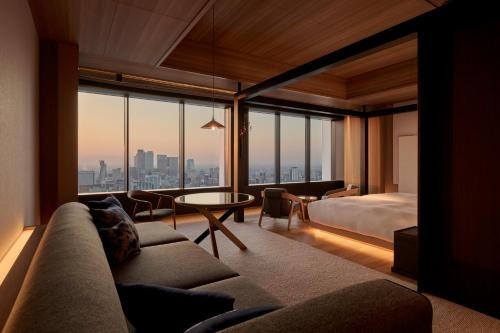 a hotel room with a bed and a couch and a table at The Royal Park Hotel Iconic Nagoya in Nagoya