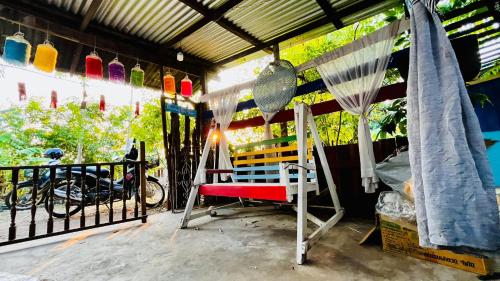 Cette chambre comprend un lit et un hamac sur une terrasse couverte. dans l'établissement peaceland farmstay, à Ban Mai (1)