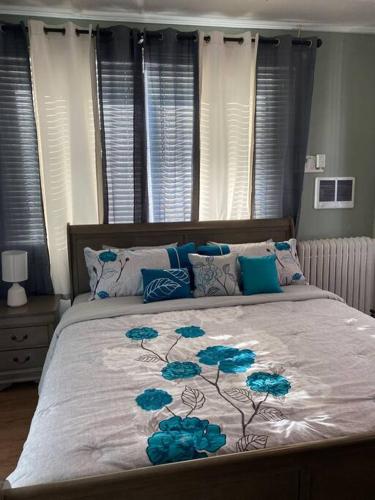 a bedroom with a bed with blue flowers on it at Classic King Suite Apartment in Schenectady