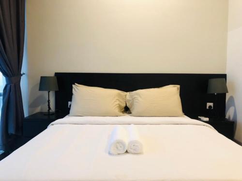 a bedroom with a bed with two towels on it at Azure Residences by Sleepy Bear Paradigm Mall in Petaling Jaya