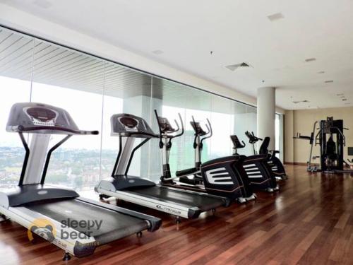 a gym with several cardio machines in a room at Azure Residences by Sleepy Bear Paradigm Mall in Petaling Jaya