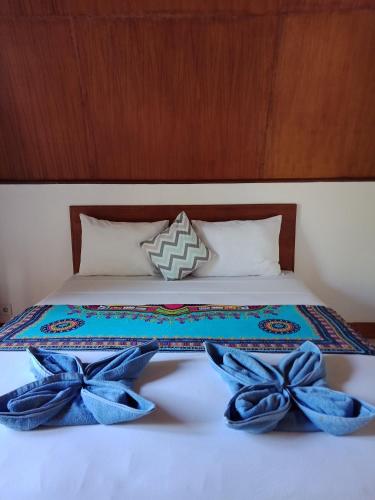 a bed with blue bows on top of it at Meno Melani guesthouse in Gili Meno