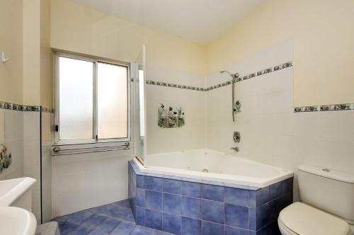 a bathroom with a tub and a toilet at Seabreeze 3 at South West Rocks - No Sheets or Towels Provided in South West Rocks