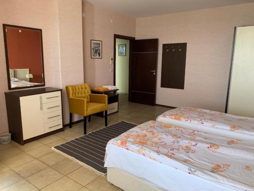 una habitación de hotel con 2 camas y una silla en Sea Apartments - Different Locations in Golden Sands, en Golden Sands