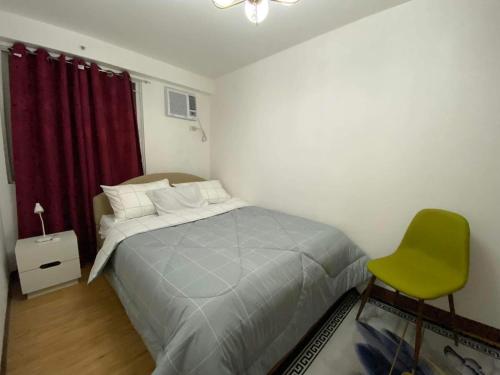 una camera con letto e sedia verde di Arezzo Place Davao Condominium a Davao