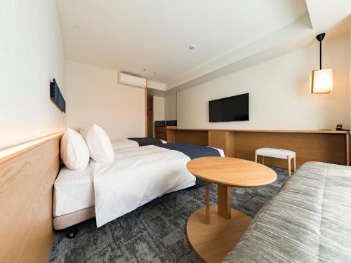 a hotel room with a bed and a table at Tokyu Stay Hida Takayama Musubinoyu in Takayama