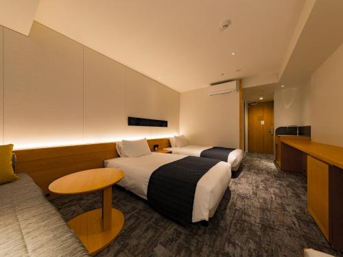 a hotel room with two beds and a table at Tokyu Stay Hida Takayama Musubinoyu in Takayama