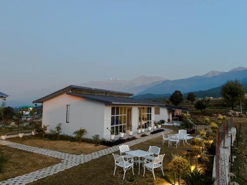 una casa con sillas y una mesa frente a ella en Bir Valley Retreat, en Bīr