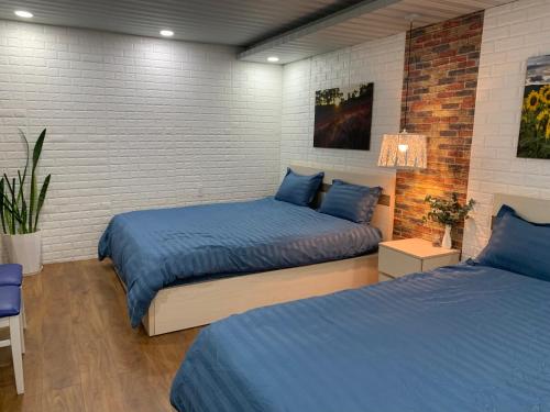 1 dormitorio con 2 camas y sábanas azules en Bồ Công Anh hostel, en Xuan An