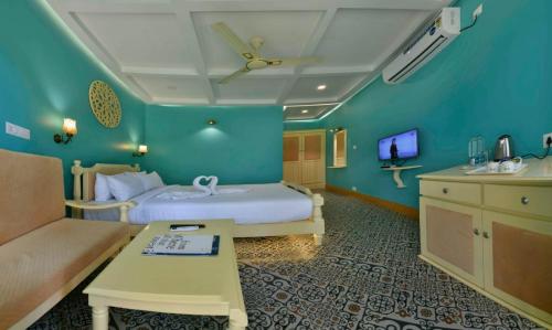 a hotel room with a bed and a couch at GoGo Land Resort & Adventurous Sports in Pūvār