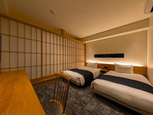a hotel room with two beds and a table at Tokyu Stay Hida Takayama Musubinoyu in Takayama