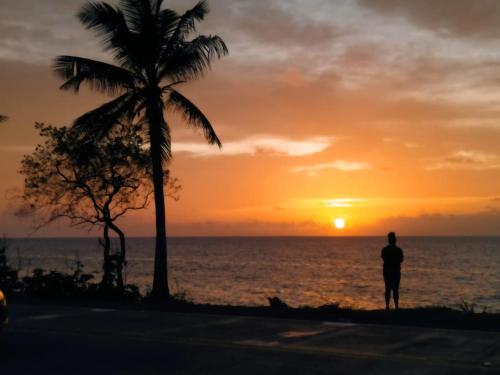a man standing on the beach watching the sunset at Alojamiento turístico Keniant's in San Andrés