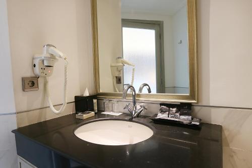 a bathroom with a sink and a mirror at Java Paragon Hotel & Residences in Surabaya