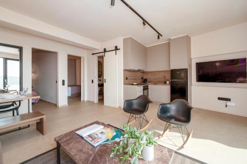 een woonkamer met een tafel en stoelen en een keuken bij Luxury House With Private Pool At Elia Beach(Mykonos) in Mykonos-stad