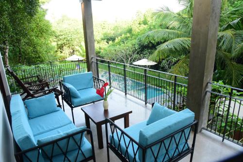 a balcony with chairs and a table and a pool at Hikka Secret Lake Resort in Hikkaduwa