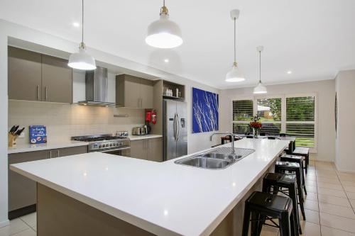 a large kitchen with a white counter top and chairs at Always Bright - A Bright Escape in Bright