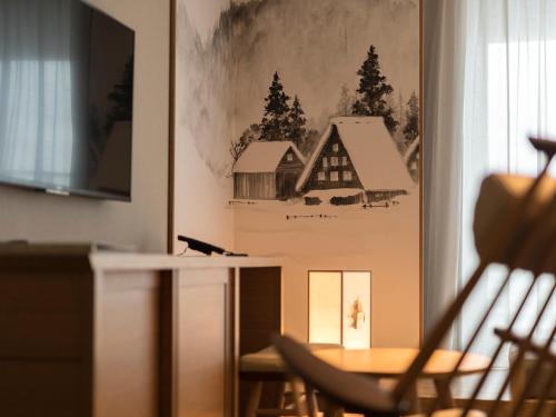 a table and chairs in a room with a picture of a barn at Tokyu Stay Hida Takayama Musubinoyu in Takayama