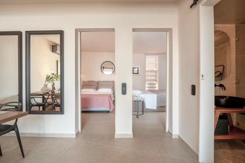 een kamer met een slaapkamer met een bed en een spiegel bij Luxury House With Private Pool At Elia Beach(Mykonos) in Mykonos-stad