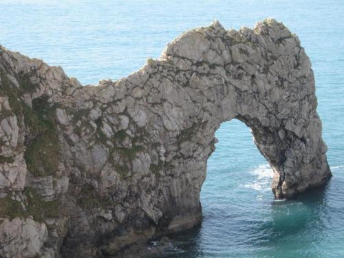 an arch in a rock formation in the water at Hudsons Guest House - Adults only in Weymouth