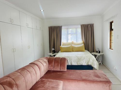 een slaapkamer met een bank voor een bed bij Zee’s Airbnb East London in East London