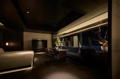 a hotel room with a couch and a television at The Royal Park Hotel Iconic Nagoya in Nagoya