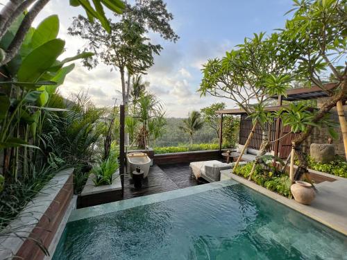 a swimming pool in the middle of a garden at The Ridge Bali in Ubud