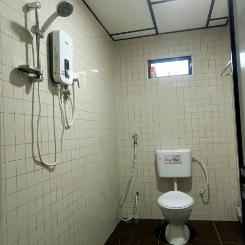 a bathroom with a toilet and a shower at The 88 Homestay in Batu Pahat