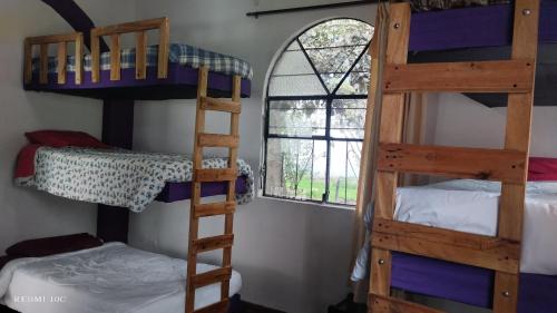a room with three bunk beds and a window at The Dream House in Quito
