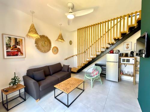 - un salon avec un canapé et un escalier dans l'établissement Aloes - Villa Salba. Panoramic view., à L'Étang-Salé