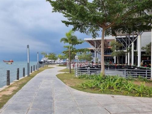 a sidewalk next to the ocean with a building at Luxury Apartment, Harbour Bay in Jodoh