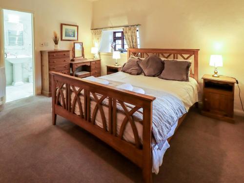 a bedroom with a large bed and a bathroom at How Head Cottage in Ambleside