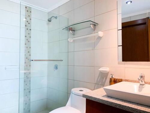 een badkamer met een douche, een toilet en een wastafel bij Hermosa Suite con vista al rio! Piscina y Parqueo in Guayaquil