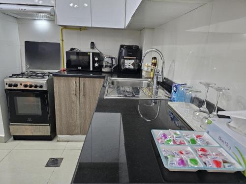 a kitchen with a sink and a stove at Luxe Studio Prime area near Airport & Attractions in Dubai