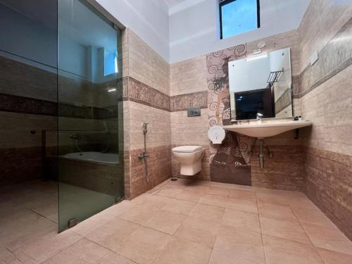 a bathroom with a toilet and a sink and a shower at Bandipur Wildlife Resort & Spa, Bandipur in Bandipūr