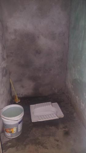 um balde e uma toalha no chão num quarto em Deep Jyoti Home stay em Bāgeshwar